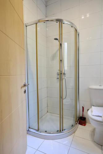 um chuveiro com porta de vidro em um banheiro em Sliema 2bed with Backyard em Sliema