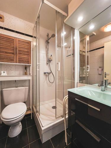 Un baño con ducha, inodoro y lavabo. en Arthur, en Le Touquet-Paris-Plage