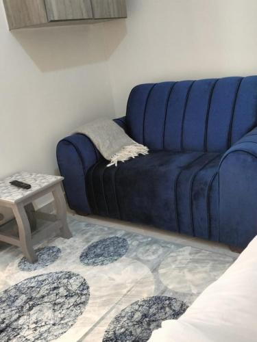 a blue couch in a living room with a table at Luxe Homes in Meru