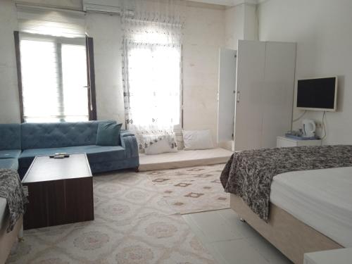 a bedroom with a couch and a bed and a tv at Derin park otel in Sanlıurfa
