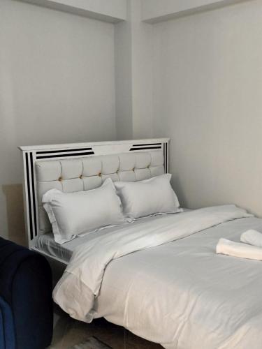 a bed with white sheets and pillows in a room at Luxe Homes in Meru