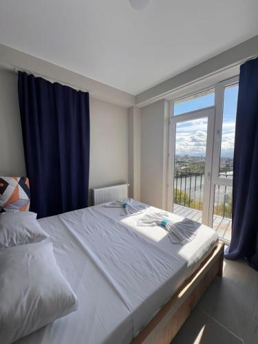 a bedroom with a large bed with a large window at Apartment nice viev History centre of the sity in Kutaisi