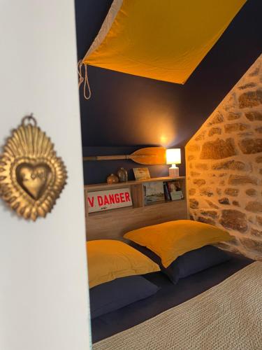 a bedroom with a bed with yellow pillows at Gîtes d Izel2 entre terre et mer prés d'un golf in Ploemel