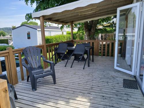 une terrasse en bois avec des chaises et une table dans l'établissement mobil home 4 personne, à Houlgate