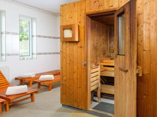 una habitación con una puerta de madera y una habitación con bancos en Chalmová CHATA 27, en Bystričany