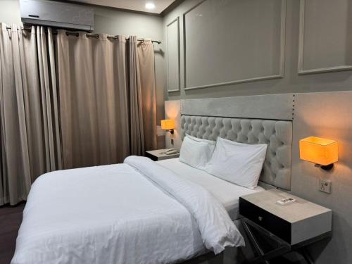 CasaNova Suites في اسلام اباد: غرفة نوم بسرير كبير مع ملاءات بيضاء