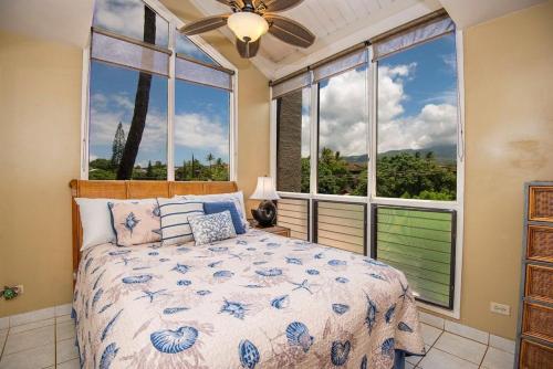 a bedroom with a bed and large windows at Hale Mahina B401 · HM B401 OceanFront 2BD Tropical Getaway in Kahana