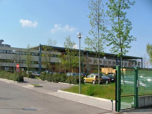 een parkeerplaats met een gebouw met auto's erin bij Stay Bologna Room and free Parking in Ozzano dell Emilia