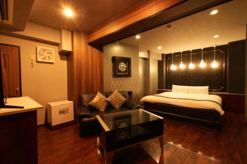 a hotel room with a bed and a couch at Nuda by H-Seven (Adult Only) in Yokohama