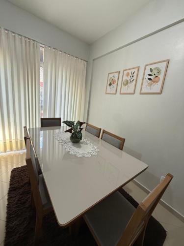 a dining room with a white table and chairs at Apartamento COP 30, Belém in Belém