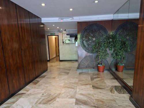 a lobby with wooden walls and potted plants at Neptuno VI in Mar del Plata