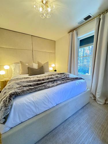 a bedroom with a large white bed with a window at Farmhouse at Montaluce Winery-2 Restaurants- Fast WIFI-Free Park-Hike-Weddings in Dahlonega