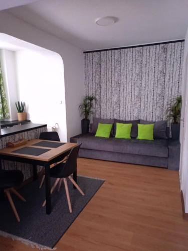 a living room with a couch with green pillows at Giżycko Studio Apartament in Giżycko