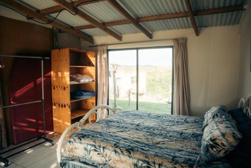 une chambre avec un lit et une grande fenêtre dans l'établissement Self-catering Furnished Holiday Cottage to rent Coffee Bay, à Coffee Bay