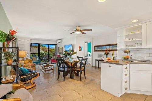 a kitchen and living room with a table and chairs at Kihei Akahi C302 · AKH C302 Spacious 2BD Condo w Ocean Breeze AC in Wailea