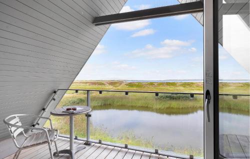 een balkon met een stoel en uitzicht op een meer bij 3 Bedroom Stunning Home In Vestervig in Vestervig