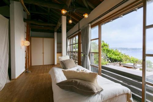 a room with a bed and a large window at mokumoku海sakanoshita in Kamakura