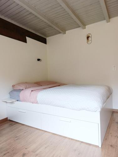 a bedroom with a white bed with pink sheets at Chez Cle'Montagne in Ovronnaz