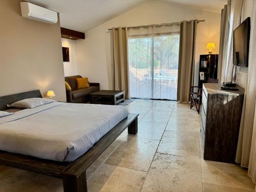 a bedroom with a bed and a sliding glass door at Casetta di Asciaghju in Porto-Vecchio