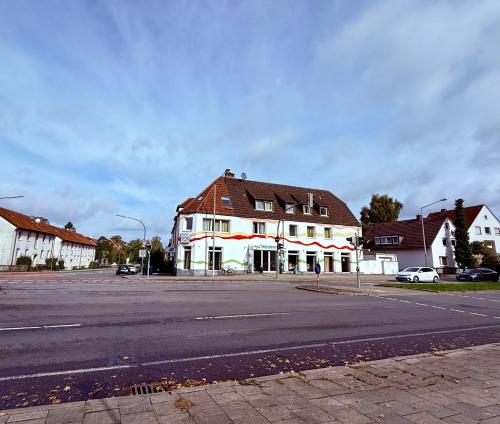 a large white house with a red and white stripe at Hotel Appart in Osnabrück