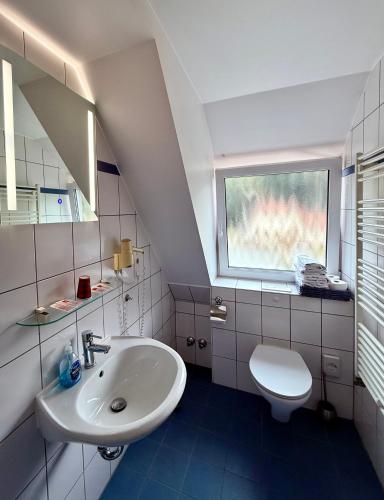 a white bathroom with a sink and a toilet at Hotel Appart in Osnabrück