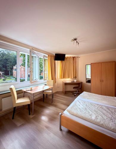 a bedroom with a bed and a table and a desk at Hotel Appart in Osnabrück
