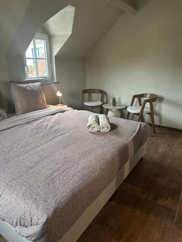 a bedroom with a bed with two towels on it at Bed and Breakfast 1691 in Valkenburg