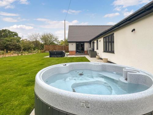 a hot tub in a yard next to a house at Seafields in Sidestrand