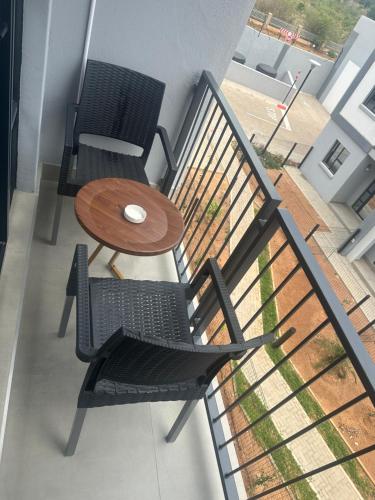 a balcony with two chairs and a table on a balcony at Kastina Suites at The Fig in Gaborone