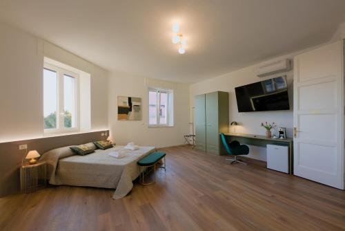 a bedroom with a bed and a desk in a room at Camera Berlino - La Casa di Carta Affittacamere in Udine