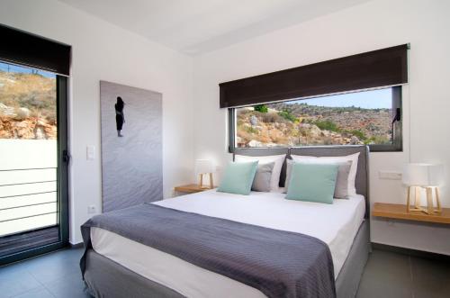 a bedroom with a large bed with a large window at Seametry Apartments in Souda