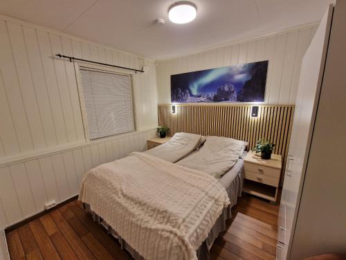 a bedroom with a bed and a painting on the wall at Apartment in Tromsø with jacuzzi in Tromsø
