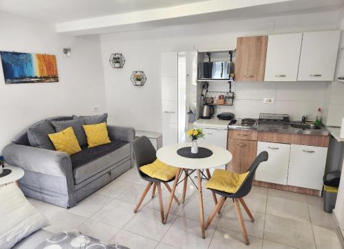 a living room with a couch and a table and chairs at Apartment Marina in Kotor