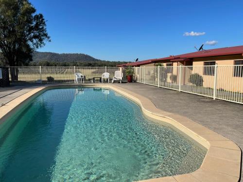 a swimming pool with blue water in a yard at Nightingale Villas in Broke