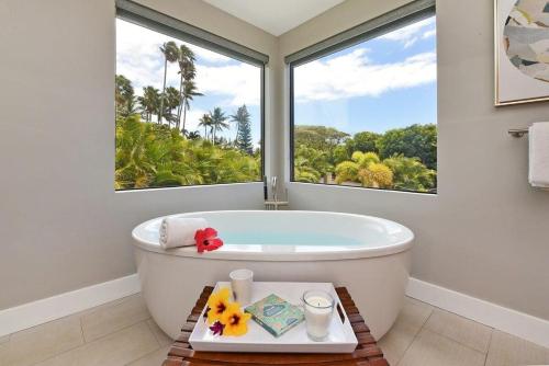 a bathroom with a bath tub with a large window at Hale Nui · HALE NUI Luxury Retreat 5BD w Private Pool Hot Tub in Kaanapali