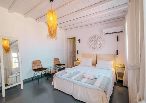 a white bedroom with a bed and a table at Manu Mykonos Exclusive Villa Luxury Beachside Stay with Private Pool by Quality Brand Villas in Kalafatis