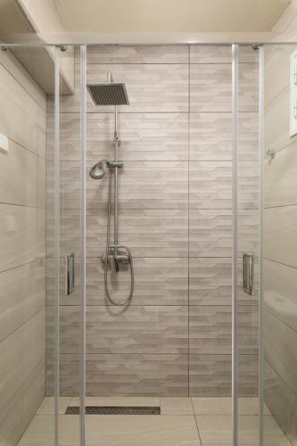 a shower with a glass door in a bathroom at Hotel Haris on the beach in Agia Marina Nea Kydonias