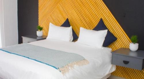 RandfonteinにあるGuesthouse in Randfonteinのベッドルーム(白いベッド1台、黄色のヘッドボード付)