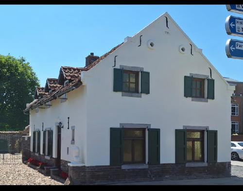 a large white building with green shuttered windows at Bed and Breakfast 1691 in Valkenburg