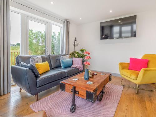 a living room with a couch and two chairs at Go Ye Cottage in Leurbost