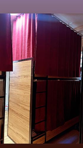 una stanza con una tenda rossa e uno scaffale di Hostel Chilli a Tirana