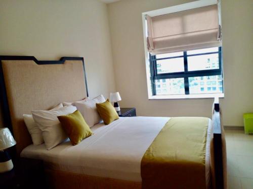 a bedroom with a large bed with a window at Gems Havelock Apartment in Colombo