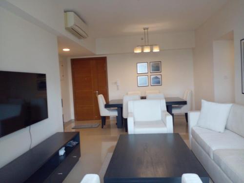 a living room with a couch and a dining room at Gems Havelock Apartment in Colombo