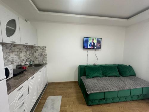 a living room with a green couch in a kitchen at Panorama in Bukorovac