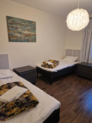 a room with two beds and a chandelier at ArcticStay Economy in Pajala