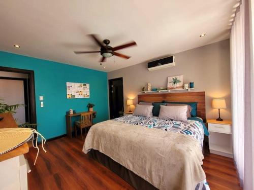 ein Schlafzimmer mit einem Bett und einem Deckenventilator in der Unterkunft Walk to Downtown Santa Ana, Near Airport, Lush Gardens, Pool, King Bed, Security in Santa Ana