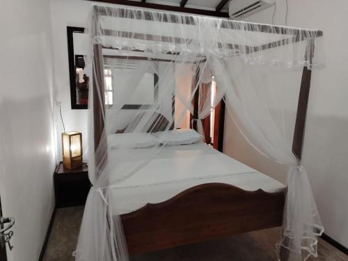 a bedroom with a bed with a canopy at Samudura Beach House, Owakanda in Rathgama