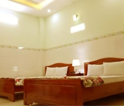 金瓯Khách sạn Gia Hưng的一间卧室，有两张床和一张带灯的桌子