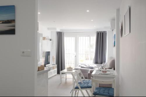 ein weißes Wohnzimmer mit einer Couch und einem Tisch in der Unterkunft SEA IRUHoUSE in Málaga