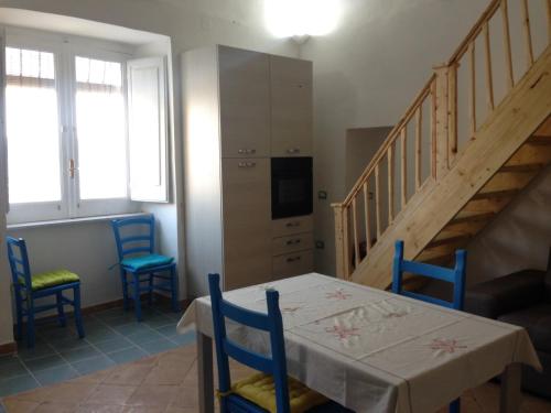 a dining room with a table and chairs and a staircase at La Casa di Titina in Procida